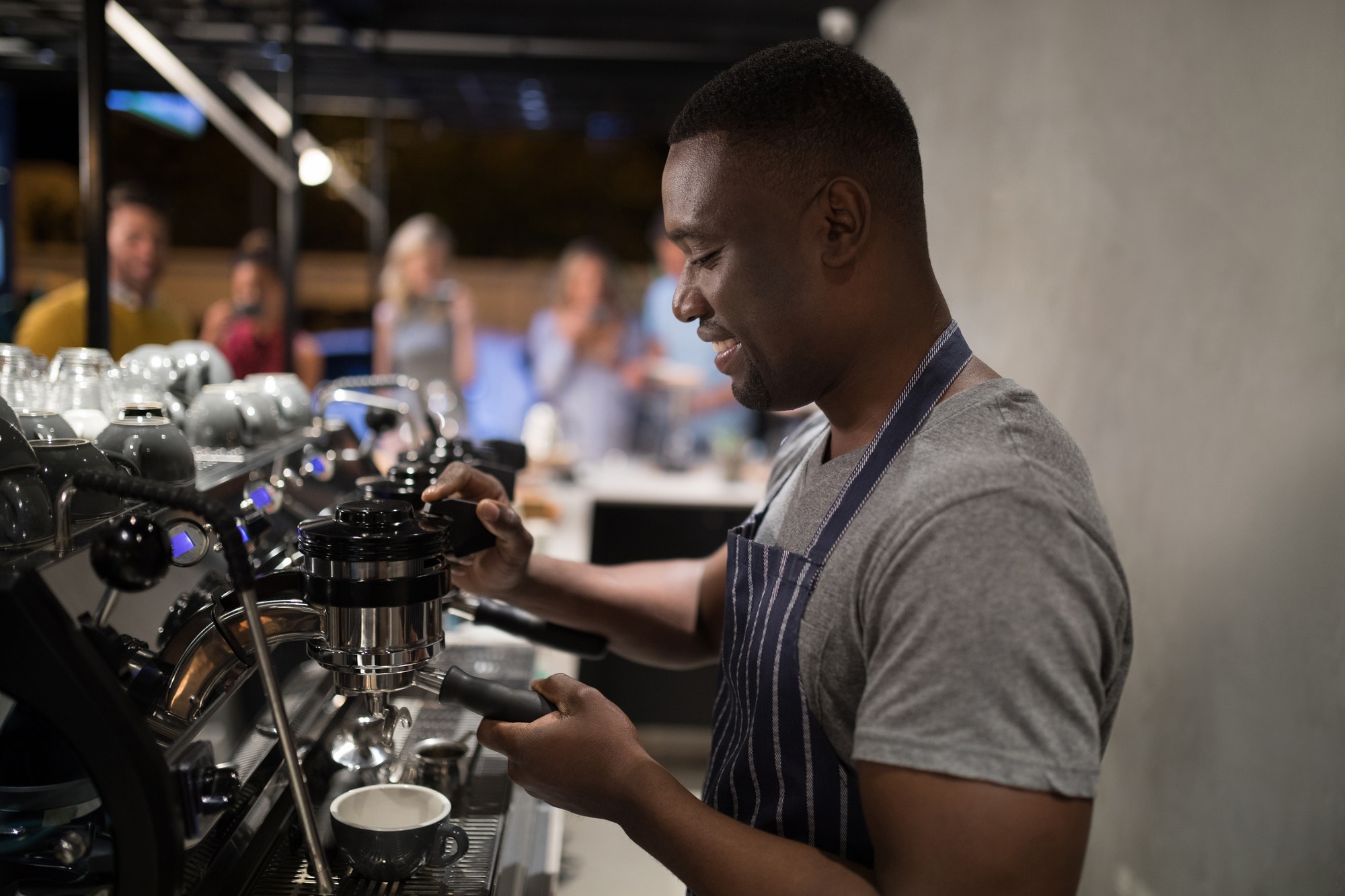 Smiling waiter making cup of coffee